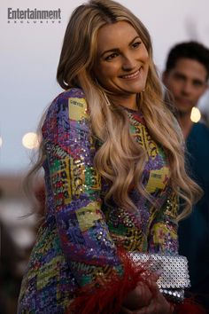 a woman with long blonde hair wearing a colorful dress