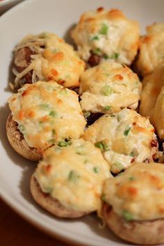 a white plate topped with cheesy stuffed mushrooms