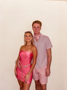 a man standing next to a woman in a short pink dress on a white background