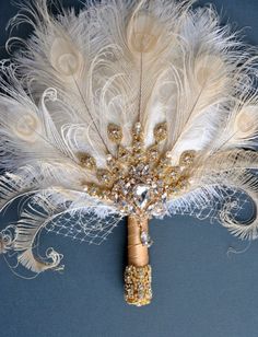 a white and gold feather boutonniere on a blue background with feathers attached to it