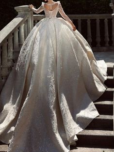 a woman in a wedding dress standing on some steps with her back to the camera