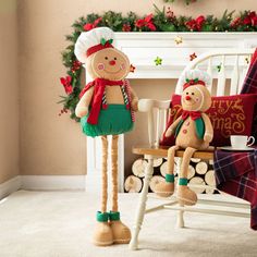 two stuffed toys sitting on top of a wooden chair in front of a christmas tree