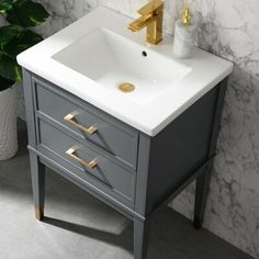 a white sink sitting on top of a blue vanity next to a potted plant