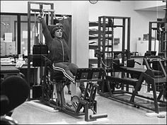 a man sitting on top of a machine in a gym