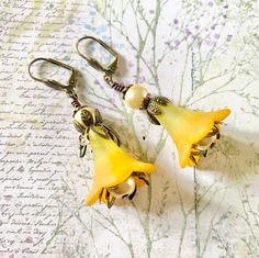 Yellow Flower Earrings, Yellow Plant Earrings, l Yellow Fairy Earrings, Romantic Earrings, Birthday Gift For Her, Gift For Girlfriend  Stand out from the crowd with these stunning Yellow flower Earrings, so colourful and eye catching.  These Lucite flowers are painted by hand and lovingly paired with antique brass and cream faux pearls. They are suspended on brass lever Back ear wires that are secure and wont fall out.  Perfect earrings for summer, weddings and parties. Ideal gift for someone sp Whimsical Flower Charm Earrings For Gift, Handmade Whimsical Yellow Earrings, Whimsical Gold Flower-shaped Earrings, Whimsical Yellow Jewelry With Ear Wire, Yellow Whimsical Dangle Earrings, Whimsical Yellow Dangle Earrings, Yellow Flower Earrings For Wedding, Whimsical Gold Flower Earrings, Whimsical Yellow Nickel-free Earrings