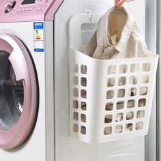 a laundry basket hanging from the side of a washing machine