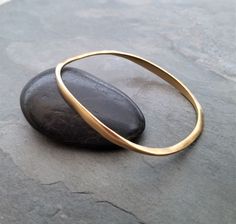 This item is made to order please allow 5 to 8 business days for your order to ship. Oval bangle bracelet, gold bangle, imperfect texture, stacking bangle, asymmetrical bracelet, unusual shape, stacking bangle This heavyweight bangle was hand carved out of wax and cast in sterling silver, it is then finished with my signature uneven surface and followed by a soft semi matte 14k gold plating. Small imperfections are left intentionally to maintain the organic characteristics of this bangle bracele Oval Bangle, Gold Bracelets Stacked, Bangle Bracelet Gold, Unique Bangle, Stacked Bangles, Gold Satin, Gold Bangle Bracelet, Gorgeous Bracelet, Bracelet Gold