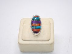 Up for your consideration is this Vintage Sterling Silver Ring. This ring features a gorgeous array of semi precious stones inlaid into the ring. The stones are coral, turquoise, sugilite, and opal doublet. Just stunning! The perimeter of the ring has a saw tooth motif that really ties it together. Pictures best describe. Excellent condition, no damages. The back is marked: "Philippines", "925", with a hallmark on top that I cannot quite make out, but took a photo of.  Ring Size is Approx.: 8.5 Measurement of Ring is Approx.: 1 1/4 inches by 5/8 inches across the front I tested this piece with acid and it is guaranteed to be sterling silver. E-mail me with any questions you may have prior to purchase. Multicolor Cabochon Rings For Anniversary, Oval Multicolor Multi-stone Rings, Collectible Multi-stone Turquoise Oval Ring, Multicolor Cabochon Gemstones In Sterling Silver, Unique Multicolor Oval Gemstones, Multicolor Cabochon Gemstones, Artisan Multicolor Multi-stone Rings, Multicolor Turquoise Gemstone Ring In Sterling Silver, Multicolor Multi-stone Turquoise Ring