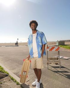 a man holding a skateboard on the street