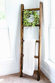 an old wooden ladder is used as a towel rack for towels and plants in the bathroom