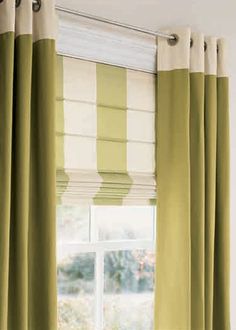 green and white curtains hanging in front of a window