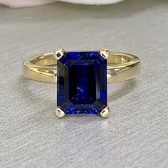 Emerald cut blue sapphire engagement ring yellow gold, Blue sapphire solitaire ring, September birthstone jewelry, Blue sapphire ring, #6132 #LabCreatedSapphire #PromiseRing #BirthdayGift #EmeraldCut #DiamondRing #WeddingRing #AnniversaryRing #BirthstoneRing #AnniversaryGift #EngagementRing Blue Sapphire Ring With Radiant Diamond Cut, Blue Sapphire Ring With Radiant Cut, Blue Sapphire Ring In 14k Gold For Promise, Blue Sapphire Promise Ring In 14k Gold, 14k Gold Radiant Cut Sapphire Promise Ring, Blue Solitaire Birthstone Ring In 14k Gold, 14k Gold Diamond Cut Sapphire Promise Ring, Blue Emerald Cut 14k Gold Sapphire Ring, Blue 14k Gold Radiant Cut Ring