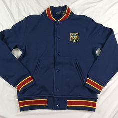 Polo Ralph Lauren Uni Crest Bomber Jacket Mens Blue Red Green Snap Button Navy Button-up Outerwear With Button Cuffs, Red Outerwear With Stand Collar And Button Closure, Varsity Outerwear With Button Closure For Work, Blue College Varsity Jacket With Button Closure, Blue Varsity Jacket With Button Closure For College, College Blue Varsity Jacket With Button Closure, Varsity Outerwear With Buttons For College, Varsity Style Buttoned Outerwear For College, Varsity Style Outerwear With Buttons For College