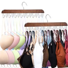 several bras are hanging on a wooden hanger in front of a white background