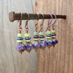 So many choices with these earrings. You can have any color of wire that you want, even purple! I fell in love with these large, irregular, center cut purple beads when I saw them. I just had to buy a few. This is the first thing I made with them, then I just kept going. You will see a few options for necklaces and earrings with these beads. These are 1.5 inches in total length. The large bead is 9mm. The smallest beads are 3x5mm rondelle beads. The small beads are a mix of green with a touch of Hypoallergenic Purple Bohemian Earrings, Purple Czech Glass Dangle Earrings, Purple Dangle Earrings With Czech Glass, Purple Czech Glass Earrings With Dangling Beads, Purple Czech Glass Drop Earrings, Purple Czech Glass Jewelry With Matching Earrings, Nickel-free Purple Beaded Earrings From Czech Glass, Nickel-free Purple Beaded Earrings With Czech Glass, Nickel-free Purple Czech Glass Beaded Earrings