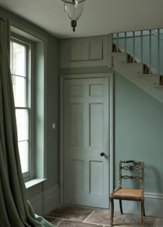 a chair sitting in front of a door next to a window