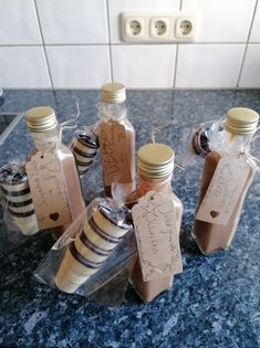 six bottles with labels on them sitting on a counter