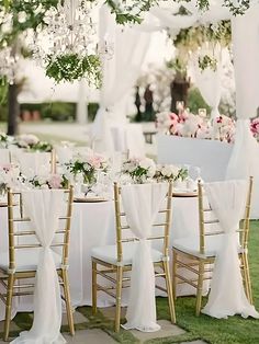 the tables are set with white linens and gold chairs for an outdoor wedding reception