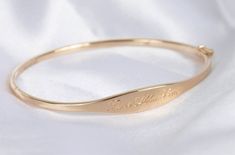 Once we perfected the sample for this bracelet we didn't take her off for 2 years. Fancy, but not too fancy. Just the right shape. Just the right width. The one thing you'll always wear, with your personalized hand engraving. Solid 14k yellow, rose or white gold bracelet with your name, text or bespoke design Engravable on front and inside Hand engraved to order The Signet Bracelet Sizing Small: 6.3in circumference; 52.10mm x 50.25mm diameter Medium: 6.8in circumference; 56.00mm x 54.00mm diamet Elegant Engraved Cuff Bracelet For Formal Occasions, Elegant Engraved Cuff Bracelet For Formal, Elegant Cuff Bracelet For Promise, Elegant Engraved Bracelet For Formal Occasions, Elegant Engraved 14k Gold Cuff Bracelet, Elegant 14k Gold Hallmarked Cuff Bracelet, Elegant Engraved Bangle, 14k Gold Hallmarked Cuff Bracelet For Anniversary, Hallmarked 14k Gold Cuff Bracelet For Anniversary