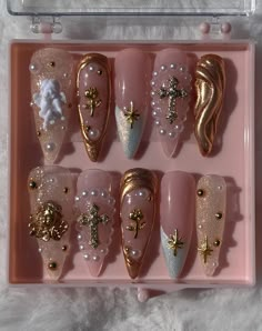 Angel White and Gold Press On Nail Set. With a variety of different gold nail charms! Each order comes with an extra five nails, and an application kit. White Angel Nails Acrylic, Gold White Nails Christmas, Glam Gold Nails, Extra Nails Designs With Charms, Angel Inspired Nails, White Nails With Gold Charms, Gold Chrome Nail Designs, Gold Gems On Nails, Rhinestone Gold Nails