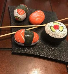 three sushi rolls with avocado on them and chopsticks in the middle