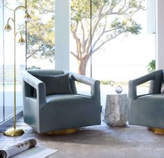 two chairs sitting next to each other on top of a rug in front of a window