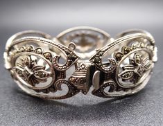 Beautiful Retro C9130s C1940s 935 Continental Silver Marcasite Bracelet in good used condition. Really nice quality German piece, has had a safety chain but one of the loops has gone, could be replaced by a jeweller. Approximate Dimensions - 20mm wide, short length 16 cm / 6.25 inches Weight - 23.68 grams Era - C1940s Hallmarks - marked 935 and acid tested. All gemstones in my listings have been examined and verified by Gemmologist Kate Matthews FGA. All pieces are in original vintage/antique co Classic Filigree Bracelets For Anniversary, Vintage Sterling Silver Bracelet For Anniversary, Estate Style Silver Jewelry Gift, Antique Hinged Bracelets For Formal Occasions, Antique Hinged Bracelet For Formal Occasions, Estate Style Silver Jewelry For Gifts, Classic Metal Bracelet With Intricate Design, Classic Metal Bracelets With Intricate Design, Vintage Sterling Silver Bracelet In Antique Silver