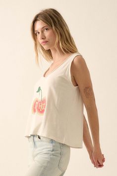 Mineral washed graphic tank top. Vintage-style cherries graphic print with "Too Hot" text. Scoop neckline with raw edge. Sleeveless with raw-edge arm holes. Scoop back. Relaxed fit. 100% Cotton. Imported top designed and printed in LA. Model wears size S. Summer Graphic Tee Tank Top, Spring Trendy Tank Muscle Tee, Trendy Sleeveless Muscle Tee For Spring, Retro Graphic Print Tank Top For Summer, Spring Graphic Tee Sleeveless Top, Spring Retro Graphic Print Tank Top, Trendy Graphic Print Tank Top For Spring, Relaxed Fit Cotton Graphic Tank Top, Spring Graphic Sleeveless Tank Top