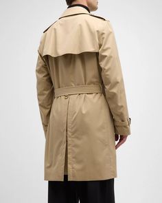 Burberry 'Kensington' trench coat made from water-resistant gabardine.Hook-and-eye collar closure​.Throat latch.Shoulder epaulettes​.Belted waist and cuffs.Side button welt pockets​.Center back vent.Burberry Check lining and undercollar​.Buckles: calf leather Cotton Lining: Cotton/viscose Made in United Kingdom Model is 6'1'/185cm.