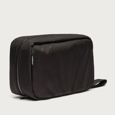 a black toilet bag with zippers on the front and side, sitting against a white background