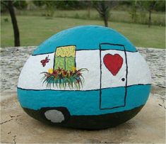 a painted rock sitting on top of a cement slab