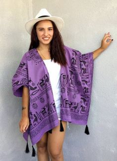 "This boho kimono jacket is made of cotton fabric. It has black tassels at the hemline. Designed with an open front, extra loose, plus size, and wide arm openings that create 3/4 length sleeves when you have it on. This tribal kimono cardigan comes in a wide and loose style, one size fits all. It adapts to different body types. The Nordic patterned purple fabric is very unique. You can use this purple poncho with jeans or shorts at Music Festivals. Also, it can wear as a beach cover-up on your s Summer Cotton Fringe Outerwear, Long Sleeve Festival Kimono With Fringe, Festival Long Sleeve Kimono With Fringe, Long Sleeve Fringe Kimono For Festivals, Vacation Kimono With Tassels One Size, One Size Tassel Kimono For Vacation, One Size Vacation Kimono With Tassels, Beach Kimono With Tassels One Size, One Size Tasseled Shawl For The Beach