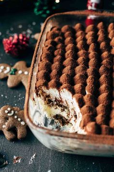 a cake in a glass dish with gingerbread cookies on the side