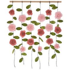 pink carnations and green leaves hanging from a wooden frame