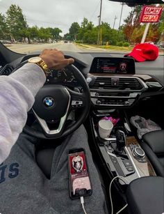 a person driving a car with their hands on the steering wheel and other electronic devices