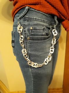 a woman is wearing a chain belt and jeans