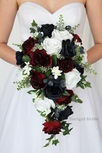 a bridal holding a bouquet of red, white and black flowers