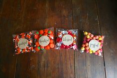 three bags filled with candy sitting on top of a wooden floor