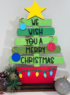 a christmas tree made out of wood with the words we wish you a merry christmas