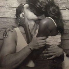 black and white photograph of a man kissing a woman