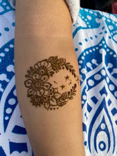 a woman's arm with a henna tattoo on it, and the moon in the middle