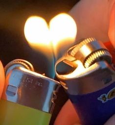 someone holding a lighter in their hand with a heart shaped light on it's side