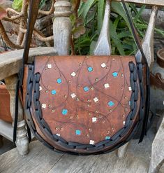 This is a beautiful vintage leather hippie boho shoulder bag...it has painted flowers on the flap and some real nice black lacing...the lacing is new and gives this bag some real rustic vibesthje leather was cleaned and oiled and conditionedthere are some minor cracks on the flap where the flap folds over but these are surface cracks and no reason to worry.... measurements are  8 inches tall, 10 inches across, gusset measures 3 inches wide and the shoulder strap drop is 16 1/2 inches Leather Satchel Saddle Bag For Festivals, Bohemian Hand-stitched Crossbody Satchel, Bohemian Hand Tooled Satchel For Festival, Handmade Bohemian Leather Saddle Bag, Bohemian Leather Saddle Bag, Handmade Brown Bohemian Saddle Bag, Bohemian Hand Tooled Leather Satchel, Bohemian Crossbody Saddle Bag With Adjustable Strap, Bohemian Saddle Bag With Adjustable Crossbody Strap