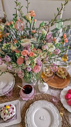 the table is set with flowers and plates