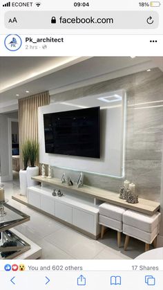 an image of a living room with white furniture and a flat screen tv on the wall