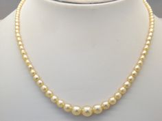 Hello and welcome to my shop.              I am offering to you this beautiful quality single row of vintage 1960's / 70's period faux pearl necklace. As you will see in the pictures the necklace is handmade in a single row of shiny polished graduated rich cream coloured faux pearl beads. The necklace clasp is a silver tone and diamante set push in type in good working order.  This fine single strand pearl necklace is in an excellent used vintage condition with no or just slight age related surf Vintage Cream Single Strand Pearl Necklace, Formal Cream Beaded Necklaces, Formal Cream Beaded Necklace, Pearl Vintage, Necklace Clasps, Faux Pearl Necklace, Pearl Beads, Cream Color, Faux Pearl