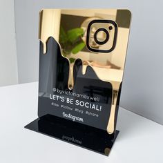 an award is placed on top of a white table with a green plant in it