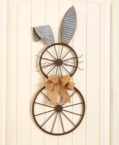 a metal wheel with two bunny ears hanging on it's side next to a door