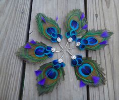 several peacock feathers are arranged in the shape of a snowflake on a wooden surface