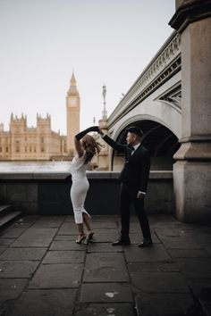 a man and woman dancing in front of big ben